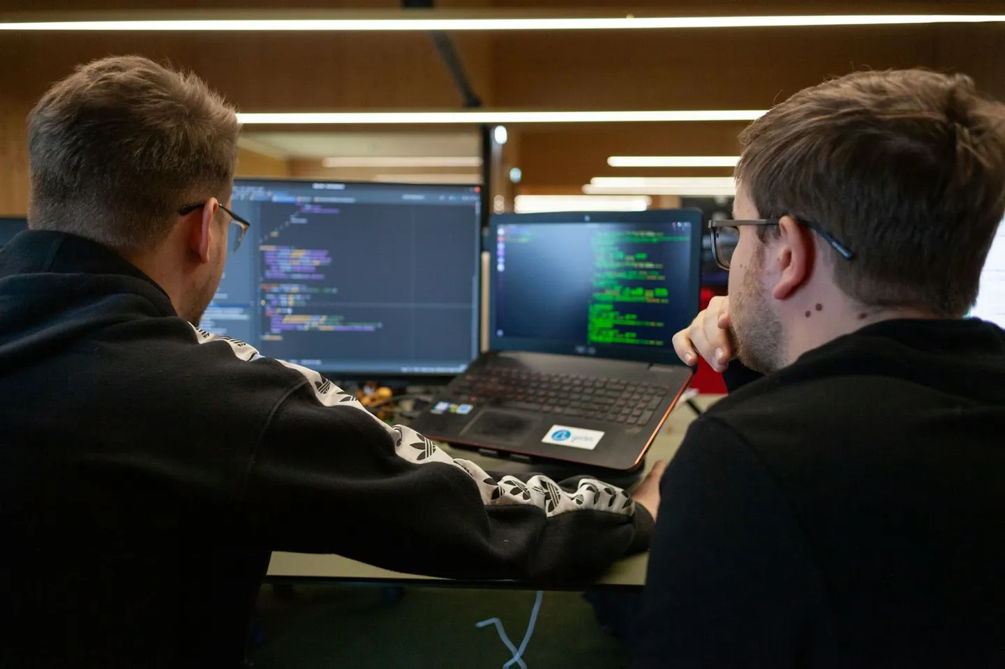 Collaboration is key to a successful testing environment a graphic depicting two developers working at a computer together